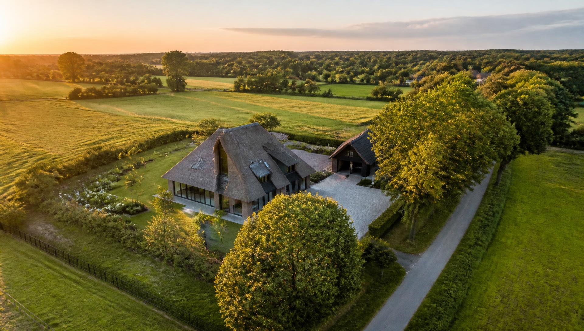 Luchtfoto van een landelijke Drentse woning bij zonsondergang